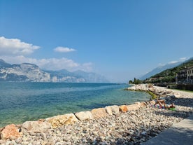 Photo of aerial view of superb Malcesine Mediterranean cityscape with colorful buildings and boats, yachts in the bay, lake Garda, Italy.