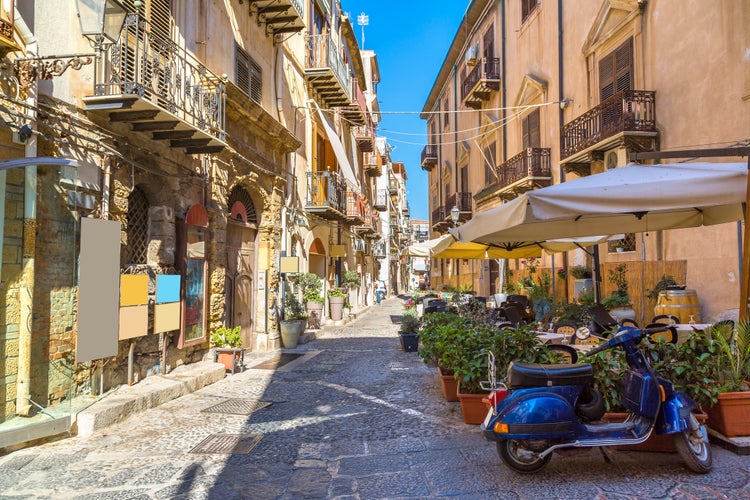 Narrow street in the old town of Cefalu in Sicily, Italy in a beautiful summer day