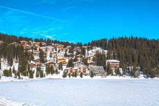 photo of beautiful snow capped mountains with Arosa village in France. Back country skier in the foreground leave their tracks in the deep snow.