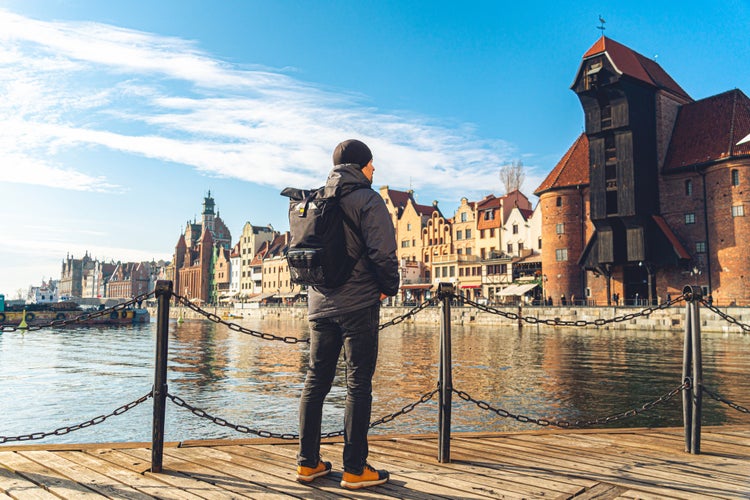 Photo of male tourist with a backpack in sunny winter in the old town of Gdansk, Poland.