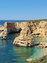 photo of an aerial view of wide sandy beach in touristic resorts of Quarteira and Vilamoura, Algarve, Portugal.