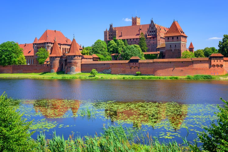 photo of view of The Castle of the Teutonic Order in Malbork by the Nogat river. Poland.