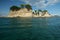 photo of view of Cameo Island, the most picturesque place in Laganas Bay, with pine trees growin Greece.g in the rocks and white cloth blowing in the wind, Agios Sostis, Zakynthos, Greece,Laganas 