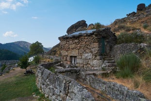 photo of Poço da Broca waterfall in Serra da Estrela Natural Park, Barriosa, municipality of Seia in Portugal, with a viewpoint in the foreground, at the end of a spring day.