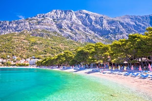 Photo of panorama and landscape of Makarska resort and its harbour with boats and blue sea water, Croatia.