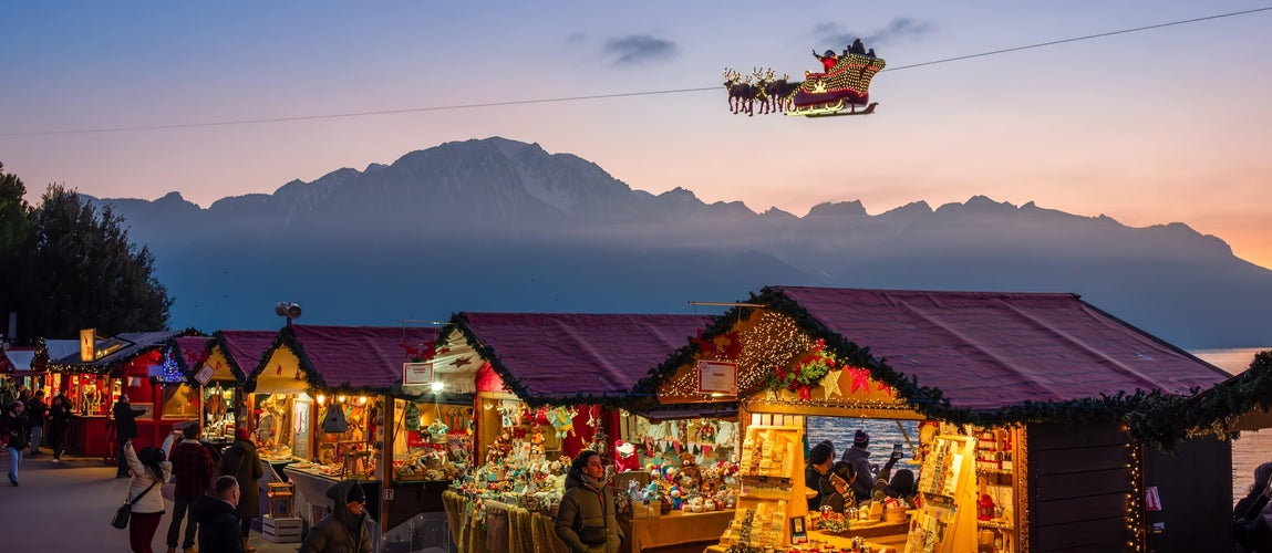 Montreux Christmas Market stalls at sunset with Santa-s sleigh and Alps in the background..jpg