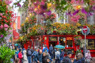 Photo of Colorful row houses with towering cathedral in background in the port town of Cobh, County Cork, Ireland.