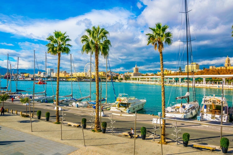 Photo of promenade surrounded by marina in the port of malaga in spain.