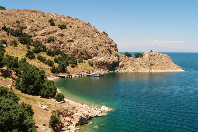 photo of view of View onto the little pier, jetty on Akdamar Island on Lake Van, Van Gölü surrounded by a bay with intense blue, green, turquoise water, Van, Turkey 2022