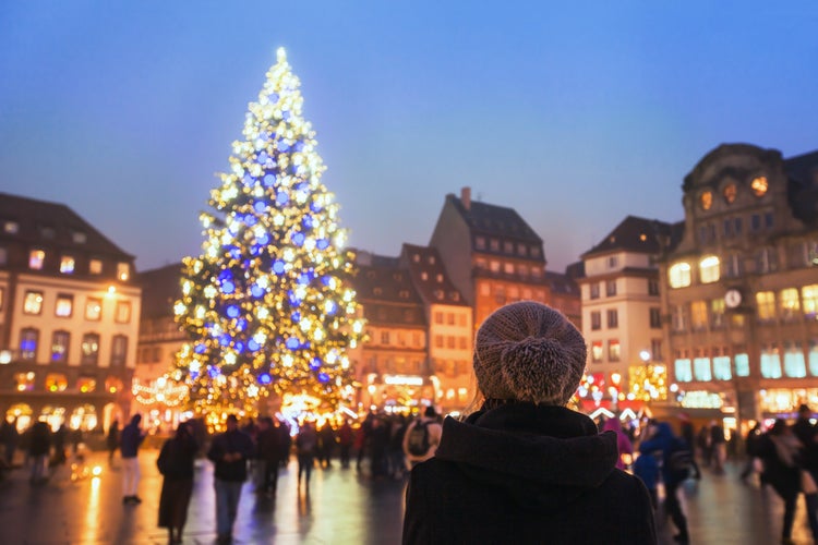 people in christmas market, woman looking at the decorated illuminated tree, festive new year lights in Strasbourg, France, Europe.jpg