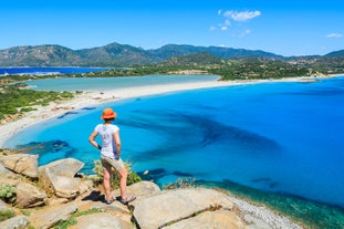 Photo of aerial view of a beautiful bay with azure sea from top of a hill, Villasimius, Sardinia island, Italy.