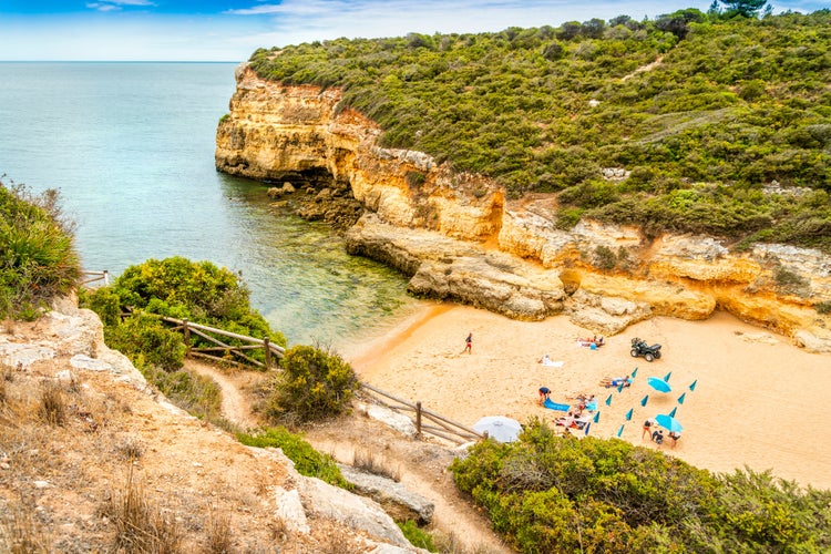 Photo of beautiful sandy beach surrounded with cliffs called Barranco, Porches, Algarve, Portugal.