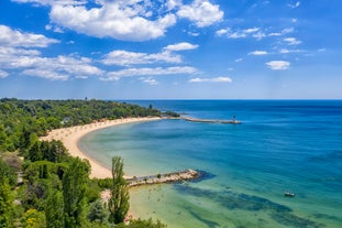 Photo of Saint Anastasia Island in Burgas bay, Black Sea, Bulgaria. Lighthouse tower and old wooden buildings on rocky coast.