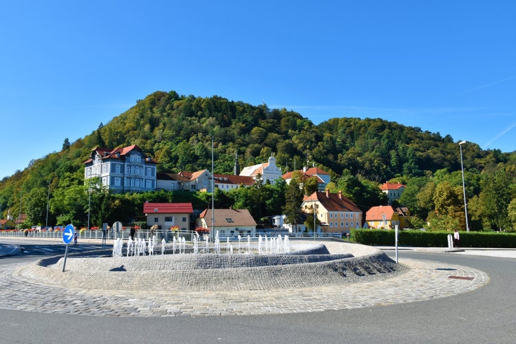 Roundabout with fountain in the middle and Parish of Celje - St. Cecilia at the base of the hill behind in Stajerska, Slovenia