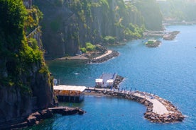 photo of aerial panorama of high cliffs, Tyrrhenian Sea Bay with pure azure water, floating boats and ships, pebble beaches, rocky surroundings of Meta in Sant'Agnello and Sorrento cities near Naples region in Italy.