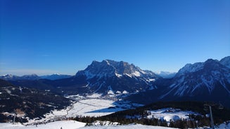 Photo of a view of the Alps from the Ehrwald, a town on the border of Germany and Austria with picturesque meadows surrounded by towering mountain ranges, including the Zugspitze.