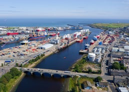 Photo of aerial view of Aberdeen as River Dee flows in a curve to the North Sea showing Duthie Park with bridge and traffic from south.