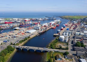 Photo of aerial view of Aberdeen as River Dee flows in a curve to the North Sea showing Duthie Park with bridge and traffic from south.