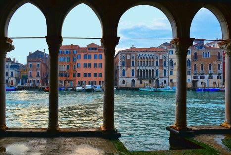 photo of The water Canal Grande and old buildings and architecture view from the balcony of the Ca' d'Oro, a gothic palace in Venice, Italy.