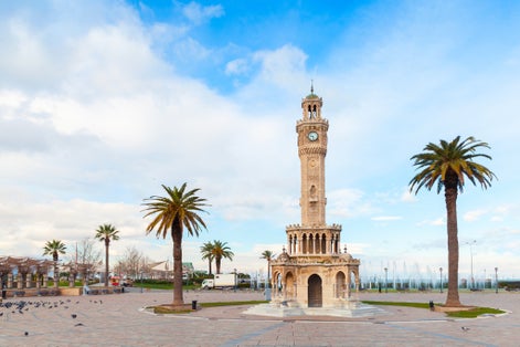 photo of Konak Square view with palm trees and old clock tower near Kemeraltı in Izmir City, Turkey.