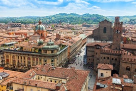 Photo of Italy Piazza Maggiore in Bologna old town tower of town hall with big clock and blue sky on background, antique buildings terracotta galleries.