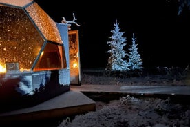 Cena al falò di vetro Igloo sotto l'aurora boreale