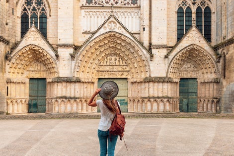 Woman tourist looking at cathedral in Poitiers- France, Vienne department ( Notre Dame la Grande)