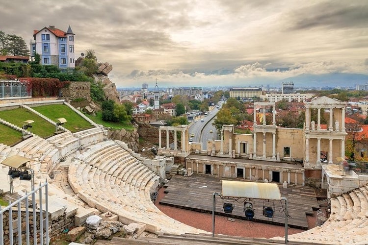 Ancient Roman theater in Plovdiv, Bulgaria, overlooking the city with a mix of historic and modern buildings, greenery, and a cloudy sky..jpg