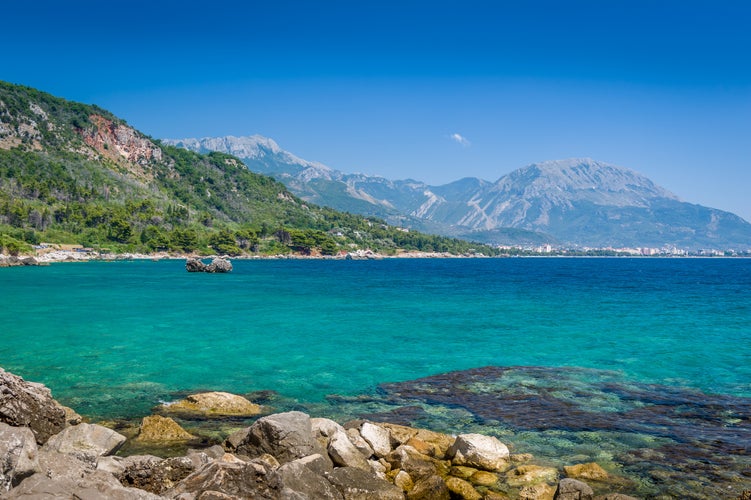 Photo of Montenegro coast seascape with perfect blue water with mountains around, blue sky near Bar town.