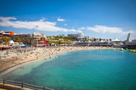 photo of aerial shot of Costa Adeje area, South Tenerife, Spain. Captured at golden hour, warm and vivid sunset colors. Luxury hotels, villas and restaurants behind the beach.