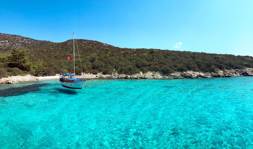 Photo of Aquarium bay Bodrum Mugla Turkey with a boat on the sea.