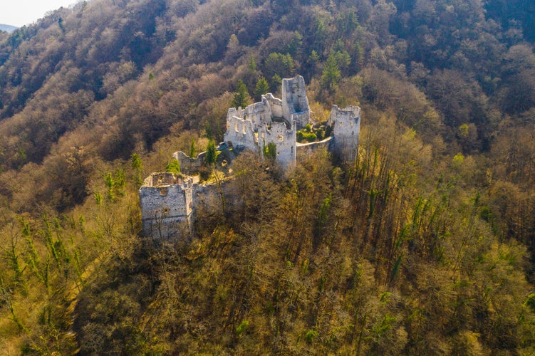 Photo of old abandoned medieval fortress ruins and forest mountain landscape aerial overhead view from drone in autumn, Samobor, Croatia.