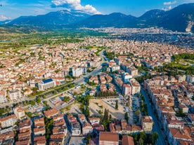 Photo of scenic aerial view of residential districts of Turkish city of Kutahya on background of hill with ruined Byzantine castle on top.