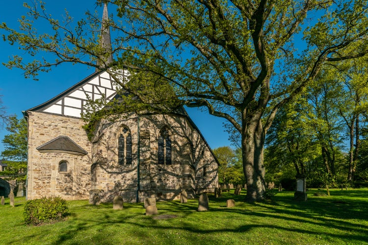 Photo of 1000 year old Stiepeler village church in the city of Bochum. Surrounded by a historic cemetery.