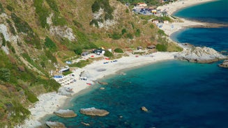 photo of an aerial view of Parghelia in Italy. Overview of seabed seen from above, transparent water and beach with umbrellas.