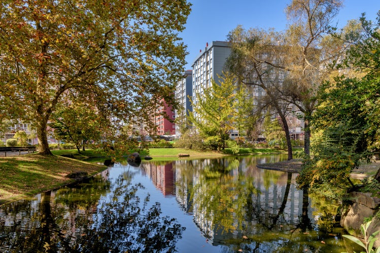 Photo of view of buildings in the city of Vigo, Spain, as seen from lake in Castrelos Park.