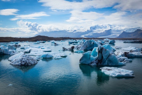 photo of big pieces of ice (floe) from glacier in the lake, ice islands, glacier and mountains, Jökulsárlón - Glacier lagoon.
