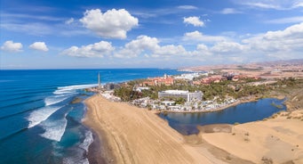 photo of landscape with Maspalomas town and golden sand dunes at sunrise, Gran Canaria, Canary Islands, Spain.