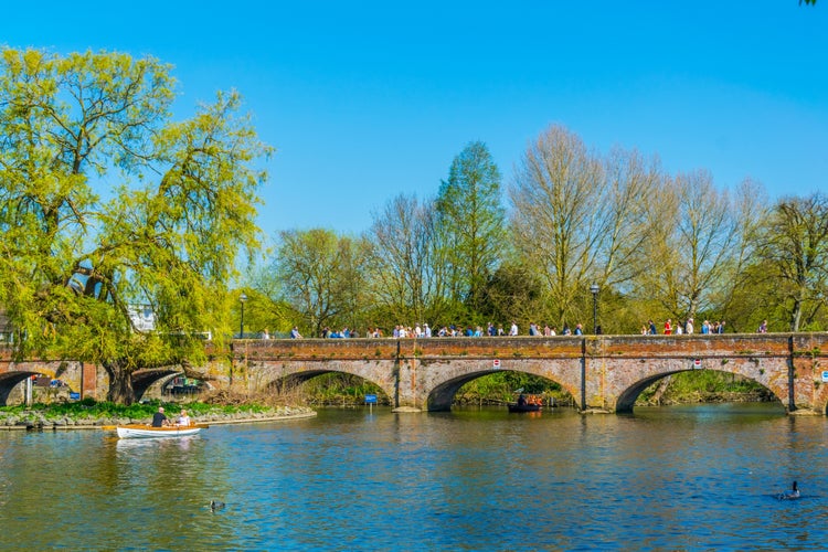 People are passing river Avon through a brick bridge in Stratford upon Avon, England