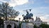 Photo of View of Balboa Park's El Cid Campeador statue, and the House of Charm building on the background with beautiful sunset sky.