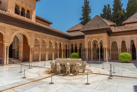 Photo of Patio de los Leones inside of the Nasrid palace of Alhambra fortress in Granada, Spain.
