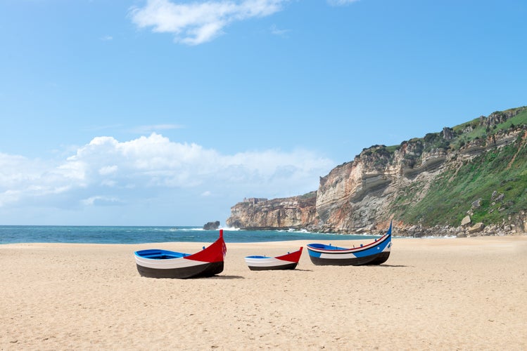 Main beach in Nazare with Traditional colorful boat on the sand - Nazare, Portugal