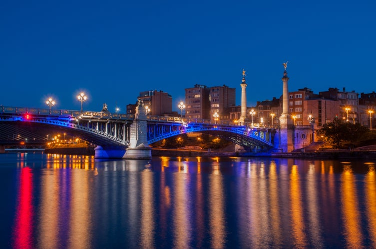 Fragnee Bridge over the river Meuse in Liège, Wallonia, Belgium, during the evening blue hour.