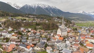 Photo of aerial view of the city of Lermoos, Austria with the Alps mountains in the background on a sunny summer day.