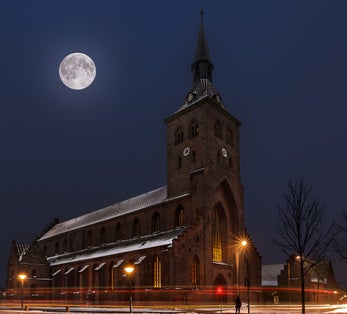 Photo of St. Canute's Cathedral at night in the center of Odense, Denmark.