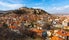 Photo of scenic aerial view of residential districts of Turkish city of Kutahya on background of hill with ruined Byzantine castle on top.