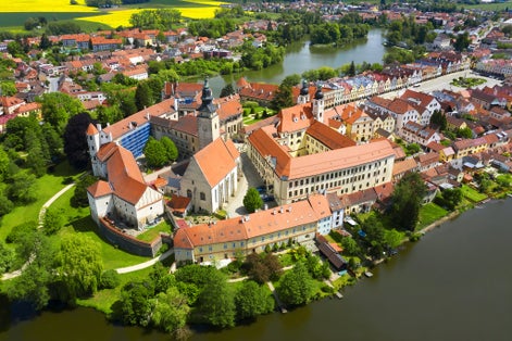 Photo of aerial view of Telc Castle and city reflected in lake, Czech Republic.