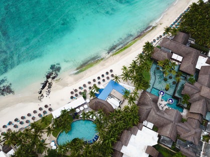 Photo of Drone overhead view of the front beach of Constance Belle Mare Plage, with pools, garden, palm trees, umbrellas and a beautiful turquoise sea ,Germany .