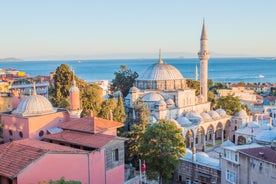 Touristic sightseeing ships in Golden Horn bay of Istanbul and mosque with Sultanahmet district against blue sky and clouds. Istanbul, Turkey during sunny summer day.