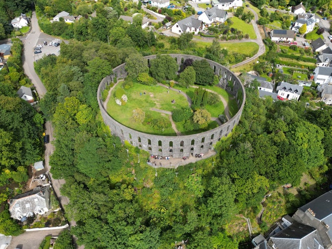 photo of view of An aerial view of McCaig's Tower and Battery Hill, located in Oban, Scotland.